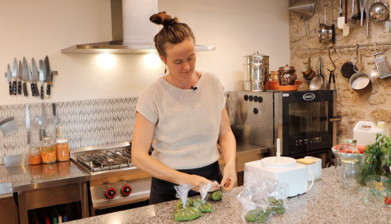 woman bagging up portions of basil and almond puree