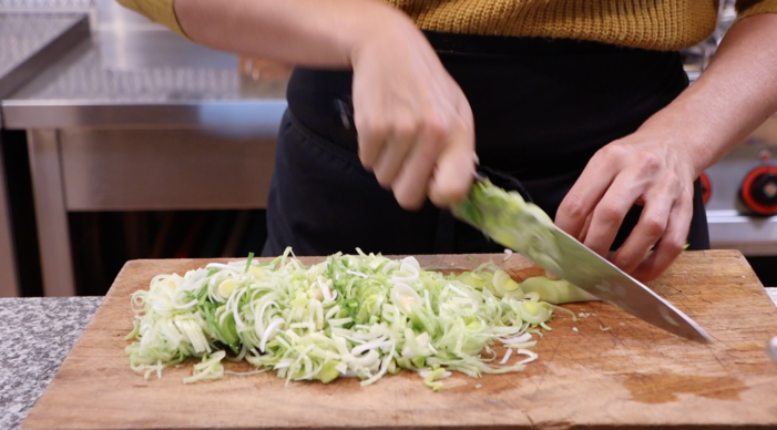 Sophie from the farming chefs cutting leek