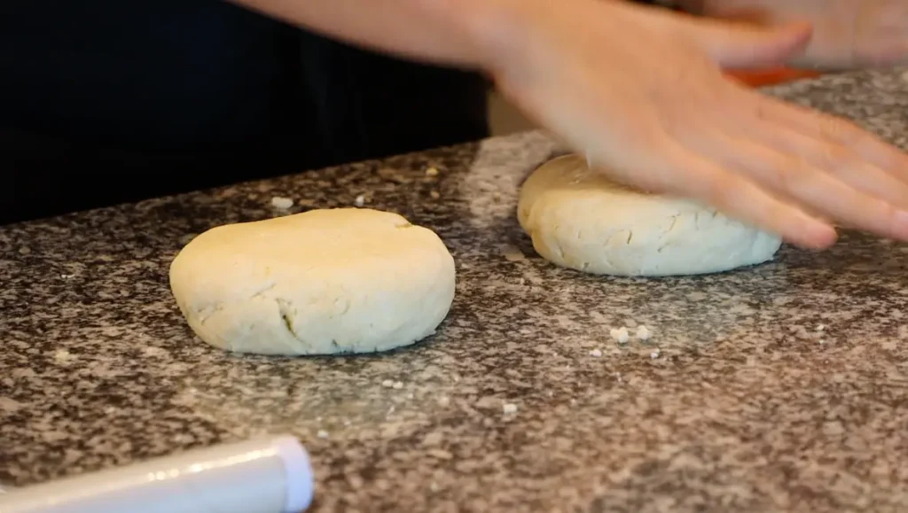 two disk shaped pieces of light colored raw dough