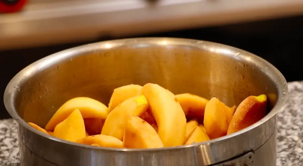 silver pot with dark yellow fruit pieces