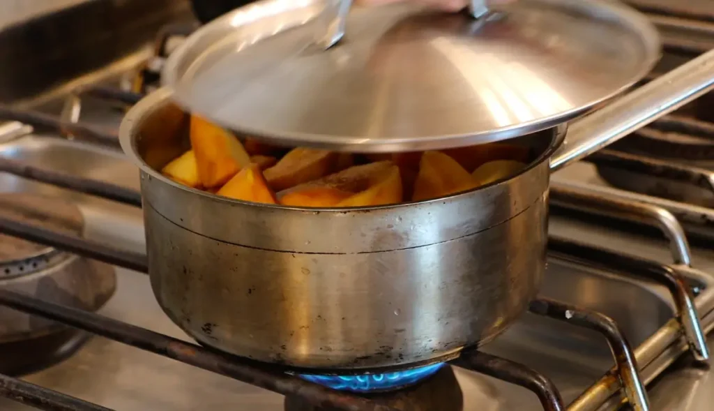 silver pot on stove, lid being closed