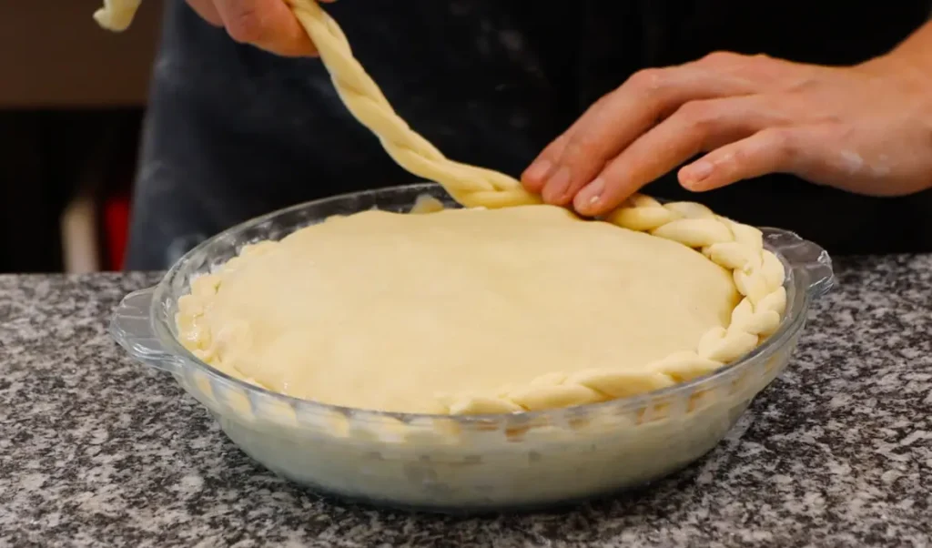 dough plaid being laid onto pie