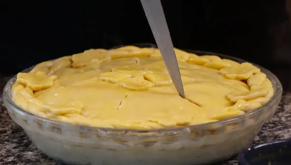 knife cutting long slits into the pie