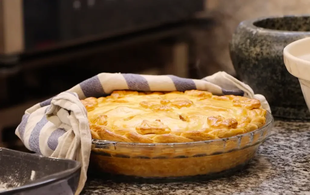 golden baked pie, blue and white tea towel in the background