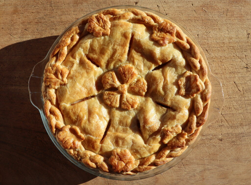 bird perspective onto a round closed pie with flower decorations