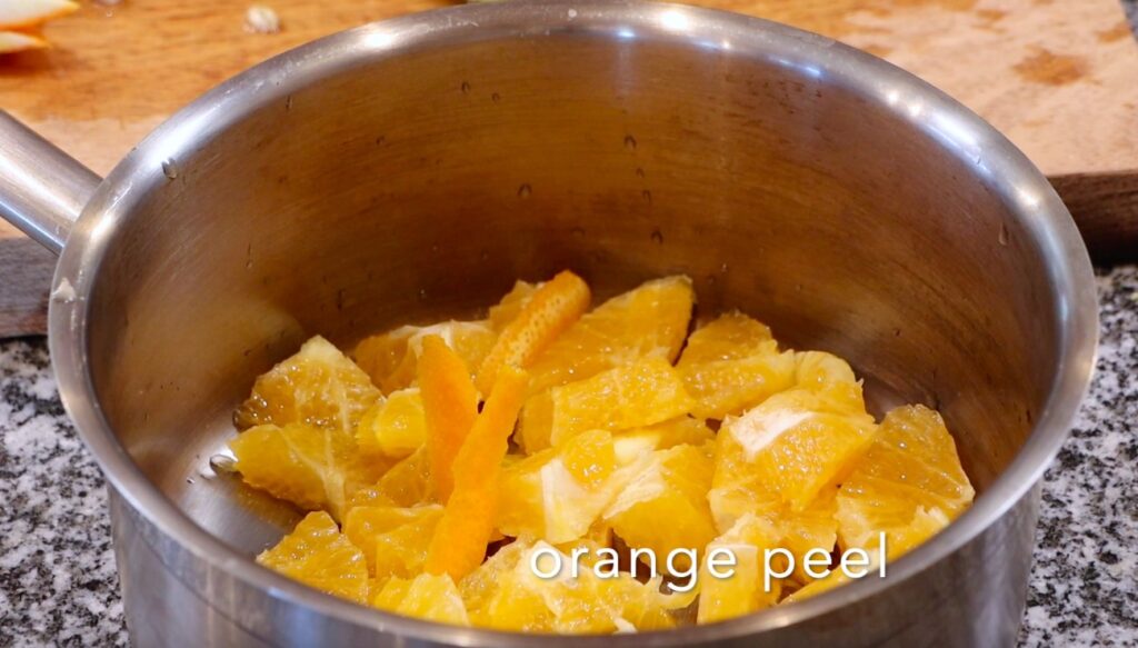 pot with chopped oranges, small pieces of orange peel, writing