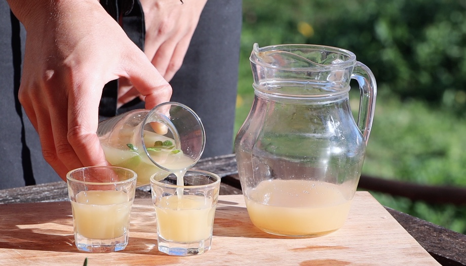 pouring yellow liquid into shot glass