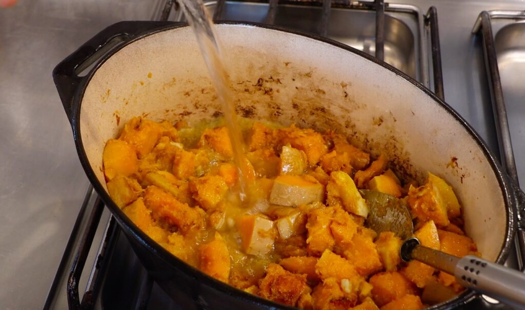 water pouring into pot with pumpkin