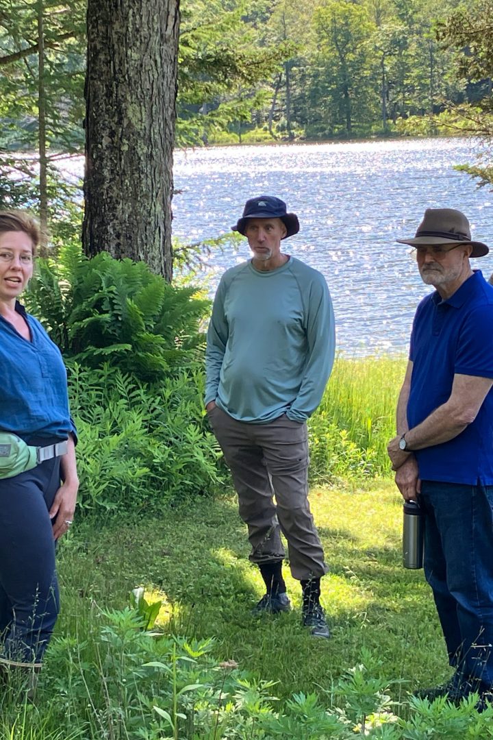 Retreat group gathered by a lake in the woods